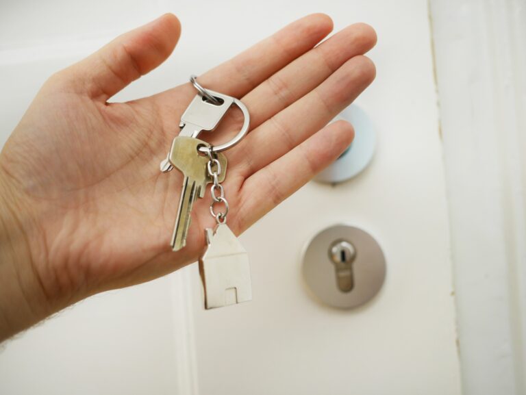 left hand holding house keys